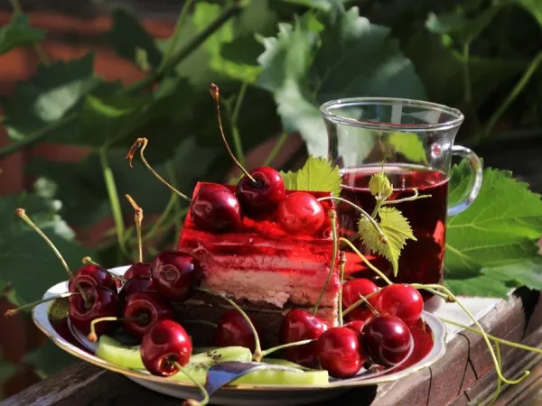 Blick auf Kirschen, Kirschtorte und ein Glas Früchtetee
